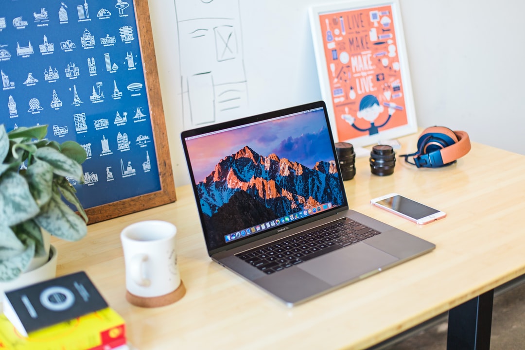 Creative workspace featuring a laptop surrounded by colorful stationery, stickers, and desk accessories